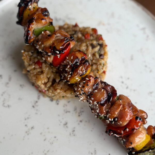 Chicken thigh skewers with colorful peppers and vegetable rice
